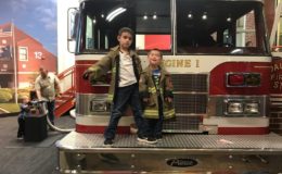 Two children from our study standing with a fire truck